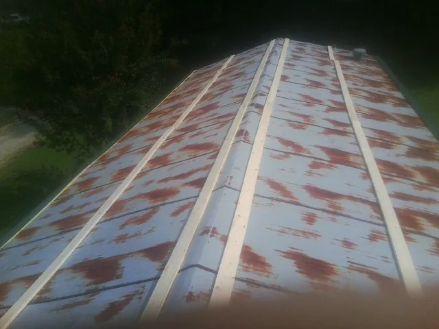 Rusted metal roof panels with new wood purlins before replacement — Storm Damage Roof Repair in Harrisburg by Roofing Brothers