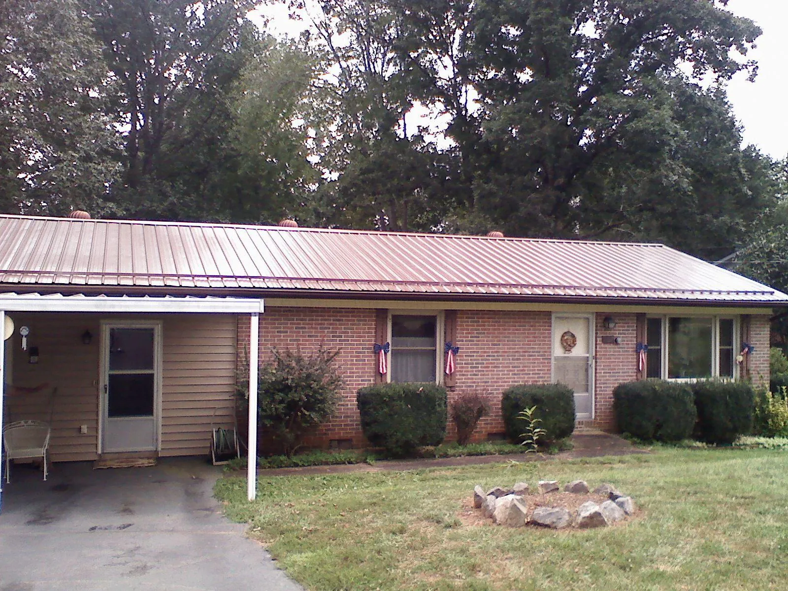 Bronze metal roof and carport on a brick ranch home — Roof Repair work by our crew in Harrisburg