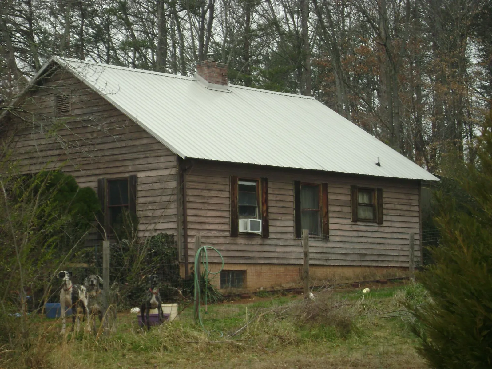 White metal roof on an old wood sided farmhouse, from a Metal Roof Installation job in Harrisburg